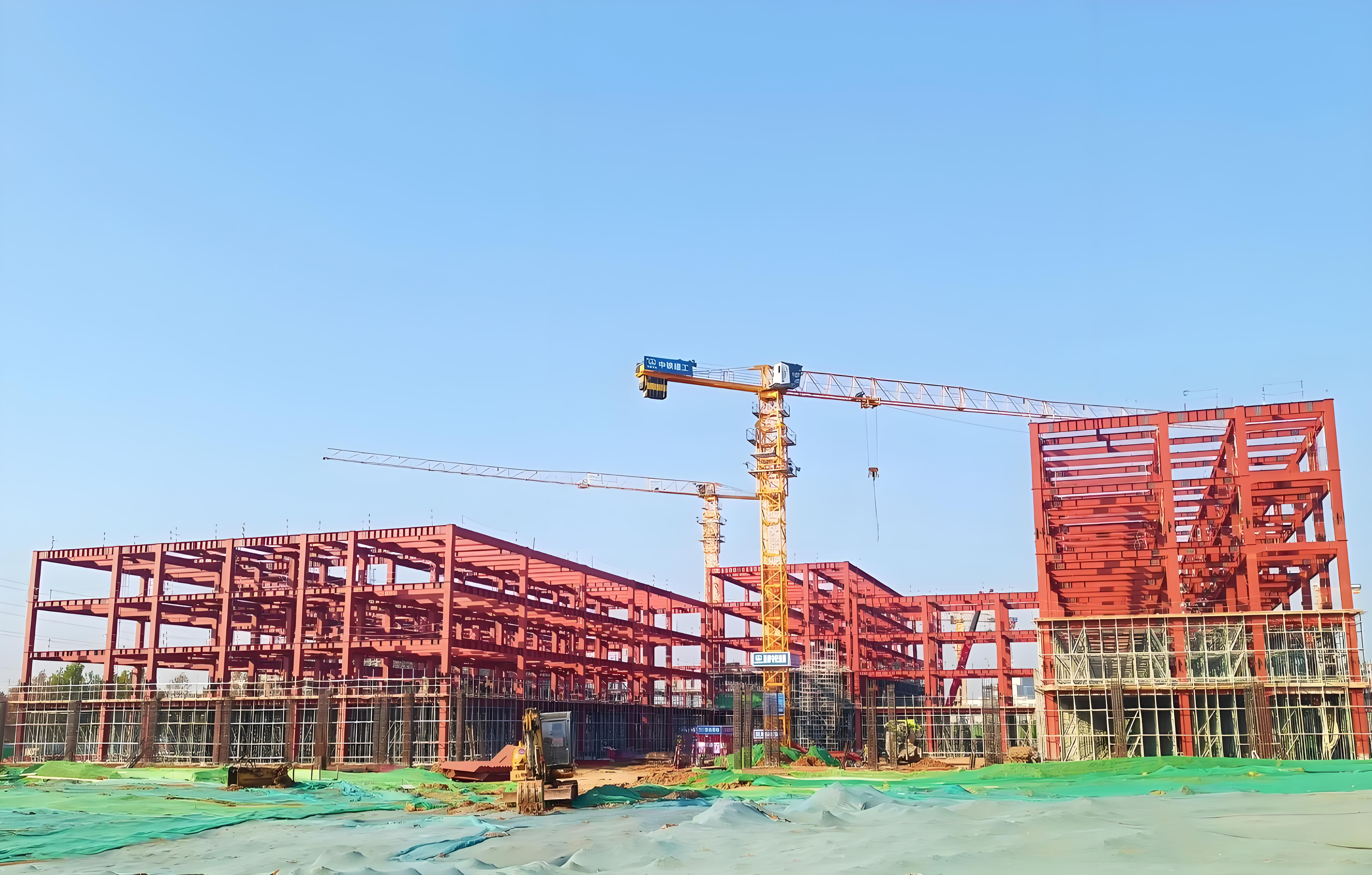 Wide view of the multi-story steel building with tower cranes